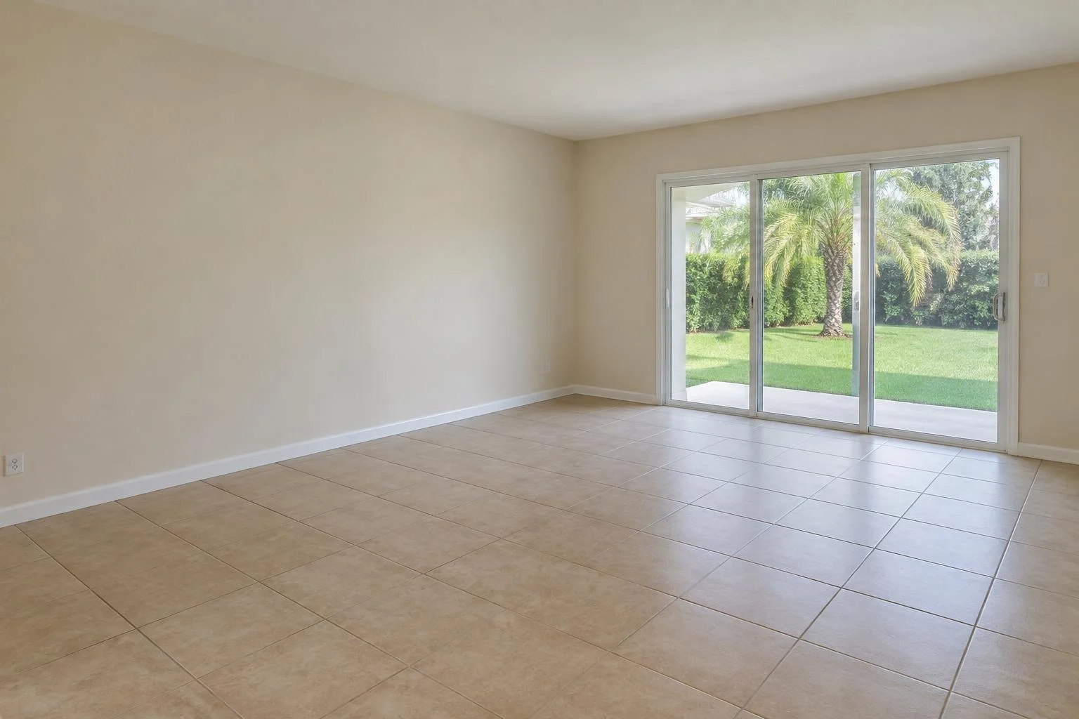Existing-floor concept: beige square tile in the same cream-walled Florida living room with sliding glass doors.